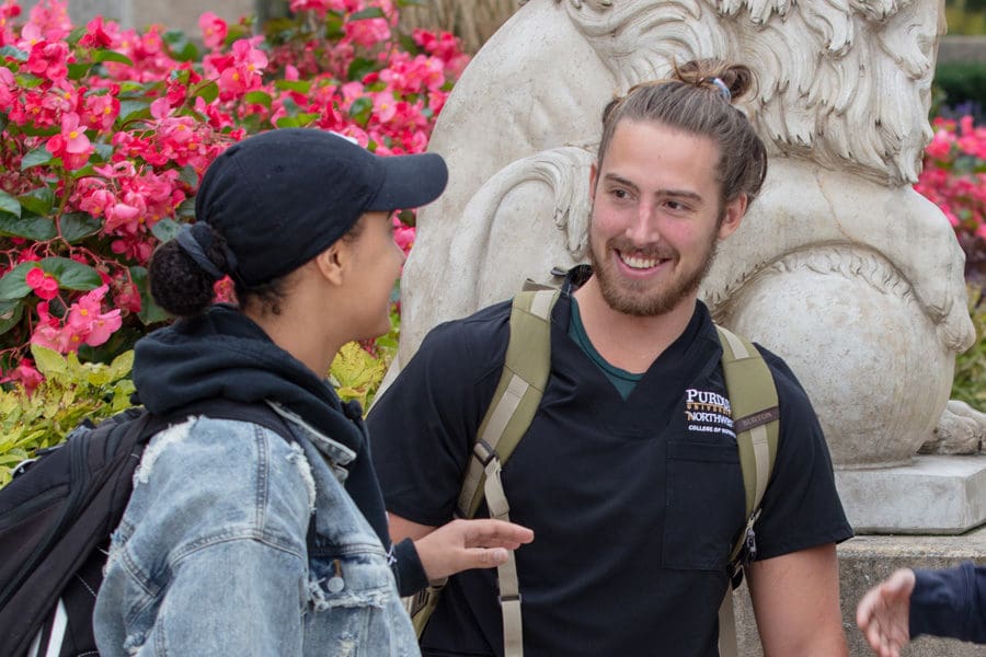 Students talk together on campus.