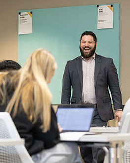 A professor stands in front of a classroom