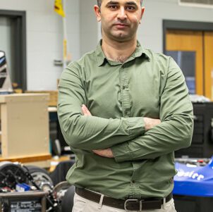 KHAIR AL SHAMAILEH, PH.D., Associate Professor of Electrical Engineering, stands in his lab