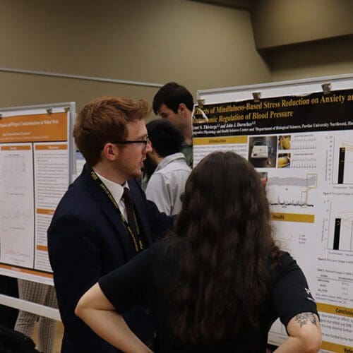 Two people look at a poster during Days of Discovery