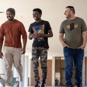Three student veterans walk on campus