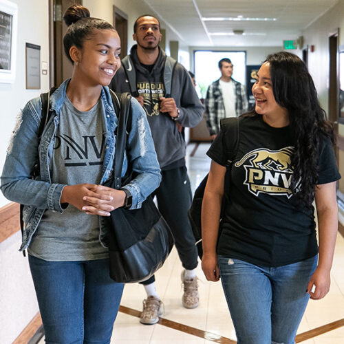 PNW students walk down a hallway