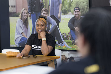 A PNW student sits at a conference table