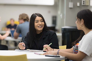 PNW students talk over a table.