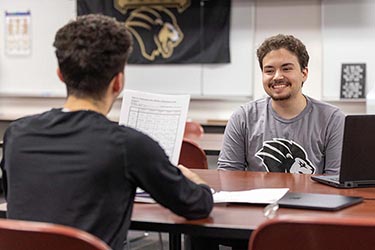 PNW students talk over a table indoors