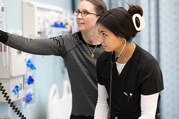 A student and an educator work in a nursing lab
