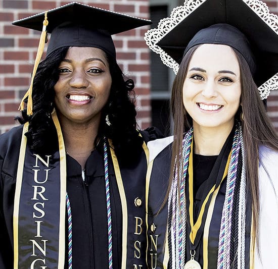 Two PNW alumnae pose together at graduation.