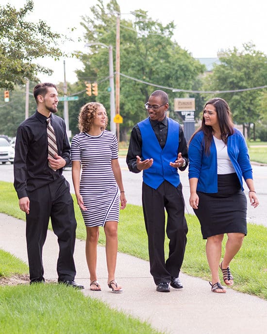 Students walk across campus in dress clothes