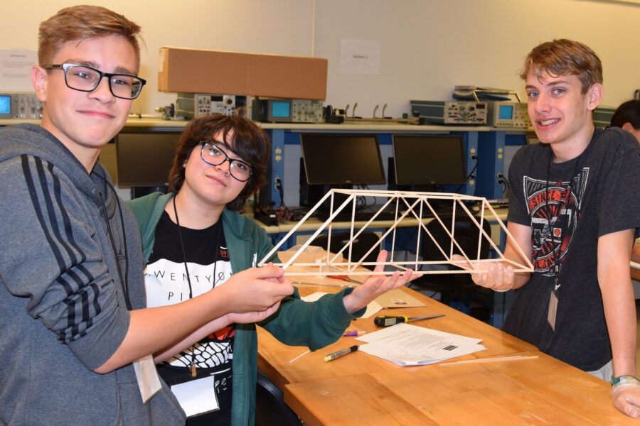 High school students build a wooden bridge at PNW summer camp.