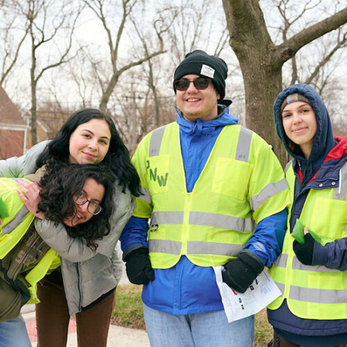 Four Honors College students pose in yellow, reflective work vests