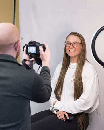 A member of the Career Center takes a photo of a student