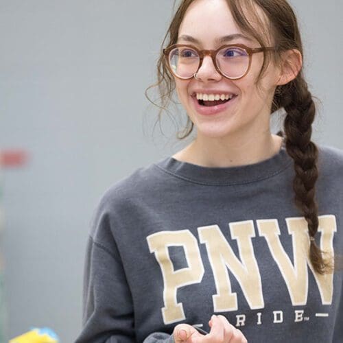 a student smiles while wearing a PNW sweatshirt