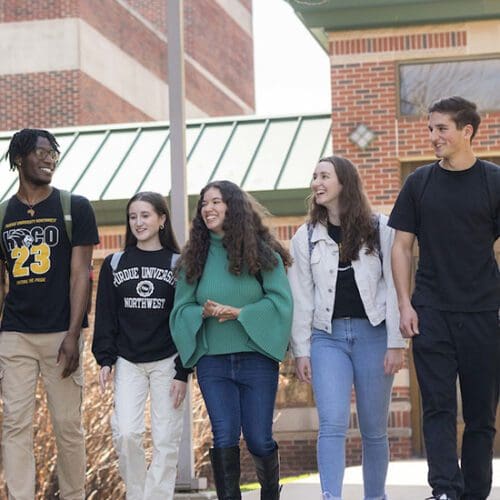 Five students walk together outdoors