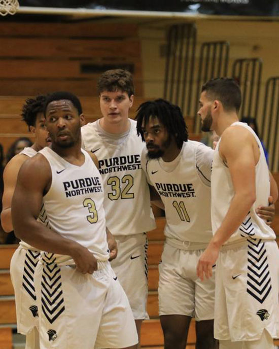 Four PNW men's basketball players stand together in uniform