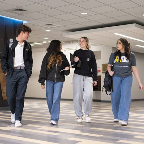 Four students walk through the Classroom Office Building