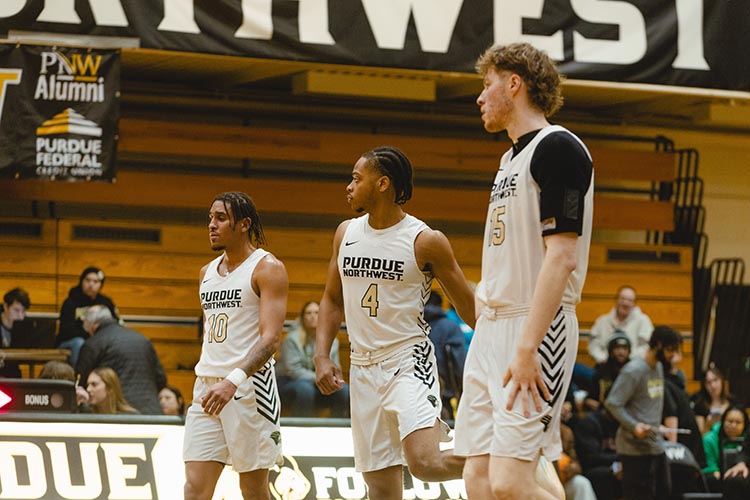 Join the Pride at the Mane Event, presented by Purdue Federal Credit Union! Join the Pride at the Mane Event, presented by Purdue Federal Credit Union! Join the Pride at the Mane Event, presented by Purdue Federal Credit Union! PNW Men’s Basketball Team Three men's basketball players with white jerseys on in the PNW gym