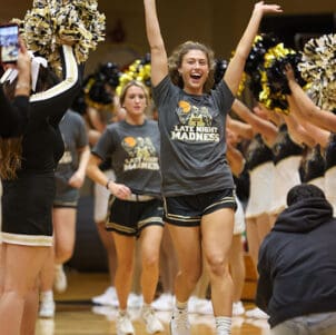 PNW women's basketball players walk between rows of cheerleaders and dance team members.