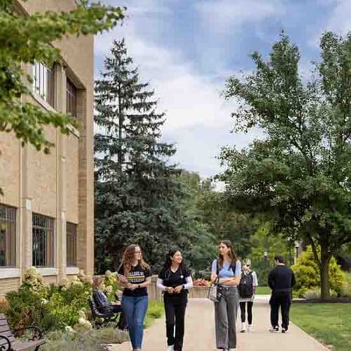 PNW students walk down a sidewalk on the Westville Campus.