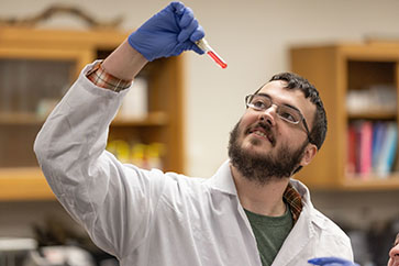 A student looks at a test tube