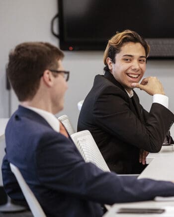 Students in suits laugh in PNW's Professional Selling Lab