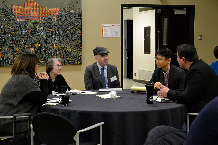 Faculty sitting around a table and talking