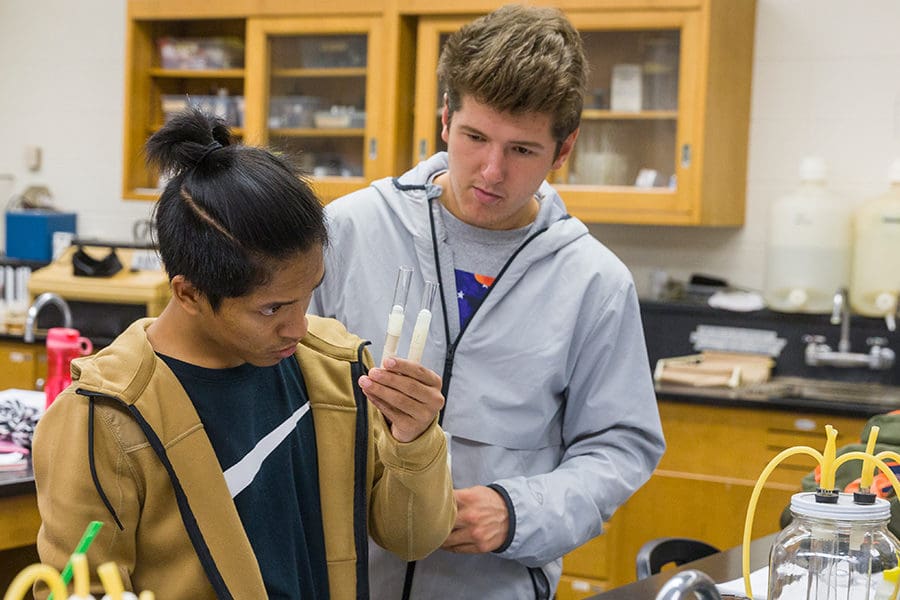 Students looking at beakers