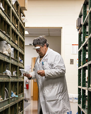 a professor looks through shelves