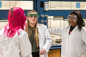 Students in PPE and lab coats