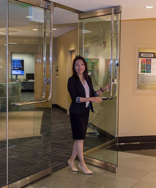 A person walks through a set of glass doors