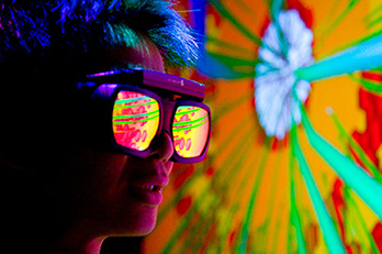 A person wearing reflective goggles looks at a blast furnace simulation