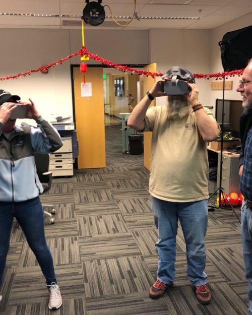 Visitors participates in hands-on experiences of AR & VR projects in the visualization lab. Participants are standing while holding VR goggles.