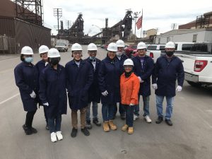10 people stand together in hard hats