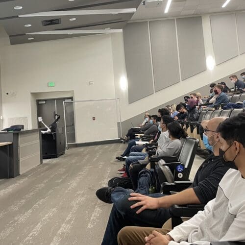 Students at a conference are pictured.