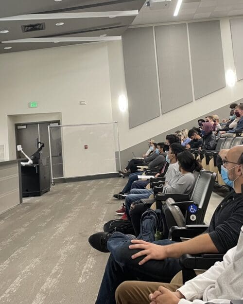 Students at a conference are pictured.