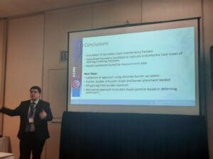 Senior Research Engineer Nick Walla standing in front of a presentation screen