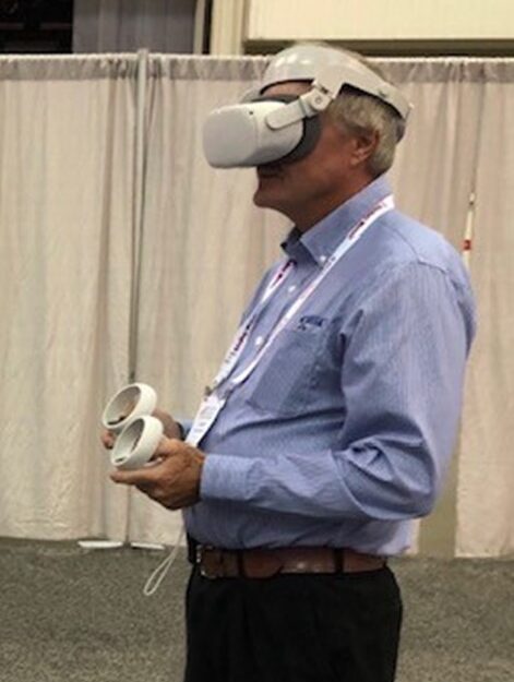 A person standing in a VR headset with VR controllers in their hands.
