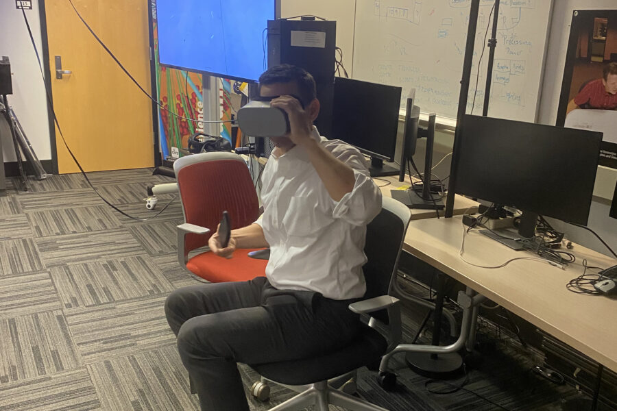 Visitor partiticpates in hands-on experiences of AR & VR projects in the visualization lab. Participant is wearing a VR headset and sitting in an office style chair.