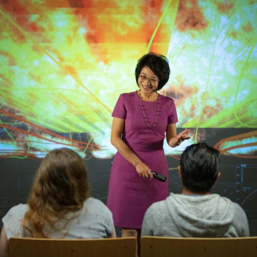 Chenn Zhou stands in front of a blast furnace presentation