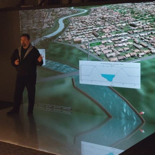 Man standing in front of screen in auditorium