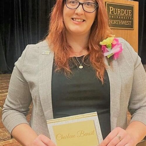 Woman holding certificate in front of stage