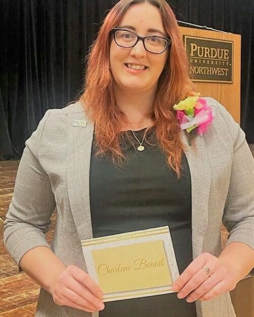 Woman holding certificate in front of stage