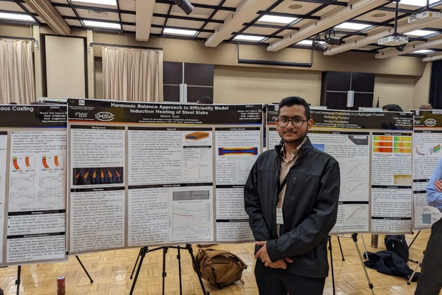 Student in a professional business attire standing in front of academic poster in presentation hall