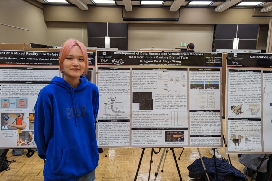 Student standing in front of academic poster in presentation hall