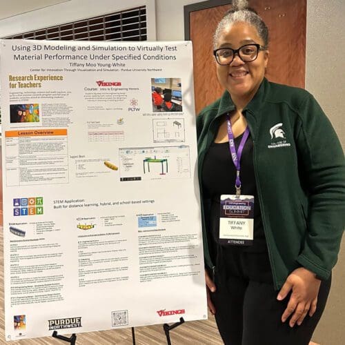 Teacher in a professional business attire standing in front of academic poster titled 3D Modeling and Simulation to Virtually Test Material Performance Under Specified Conditions