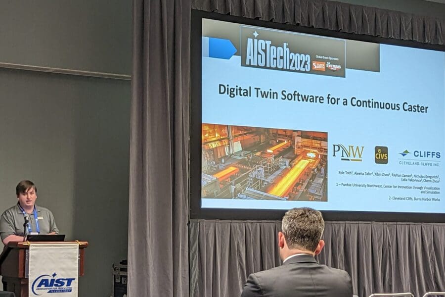 Man standing in front of screen featuring PowerPoint slide at podium in conference room