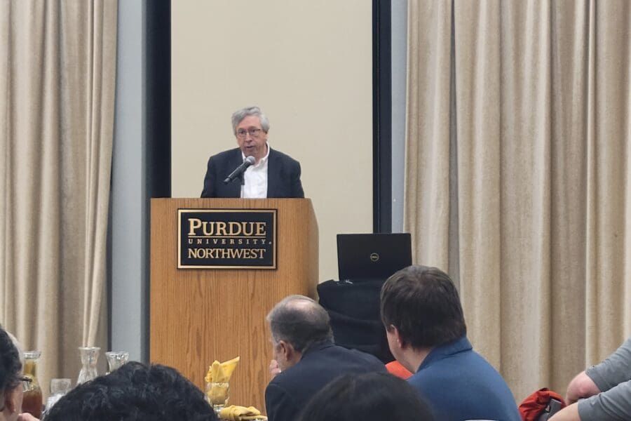 Man standing at podium in front of seated guests