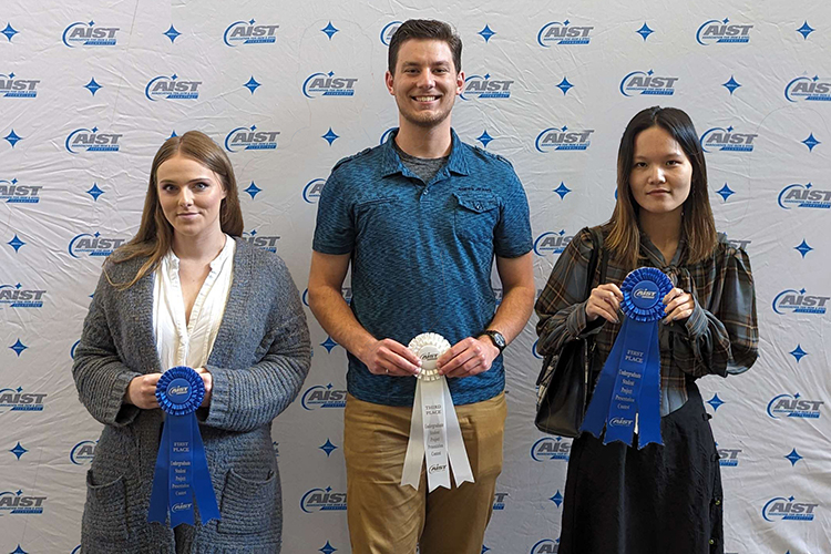 Three students pose with ribbons