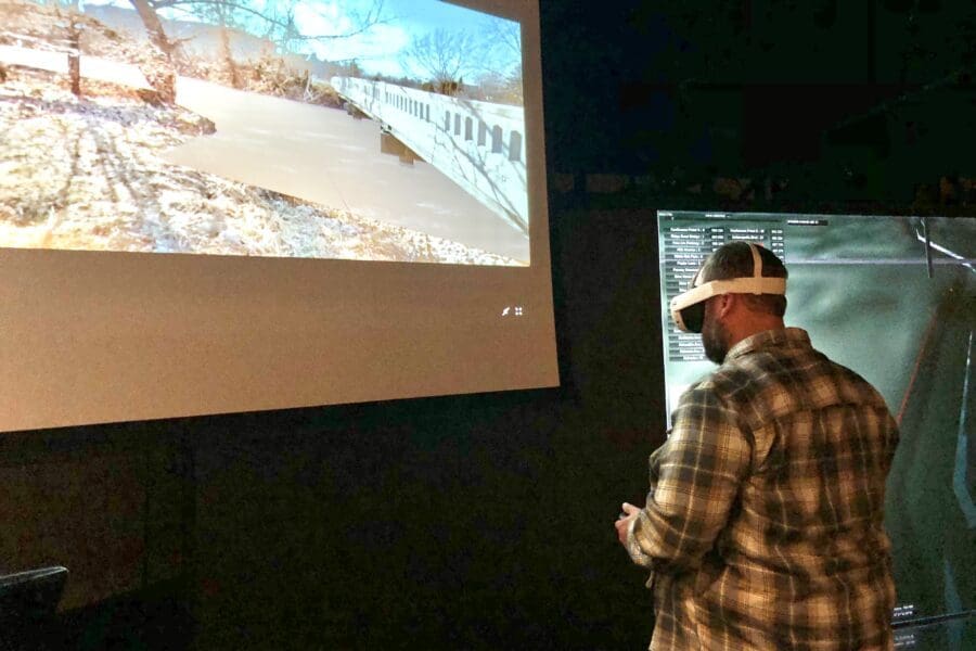 A person wearing a flannel shirt uses the Virtual Flood Simulator