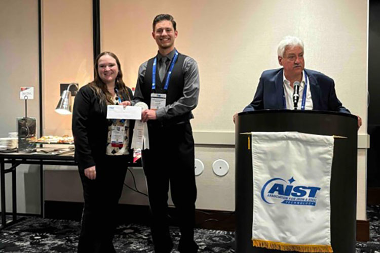 Two students pose together with awards