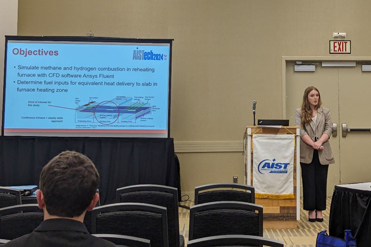 A student stands next to a podium and gives a presentation